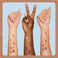 Features three arms with diverse skin tones, each displaying swatches of the eyeshadows from the NYX Professional Makeup Holiday Gingerbaddie Palette, illustrating how the colors appear on different complexions.